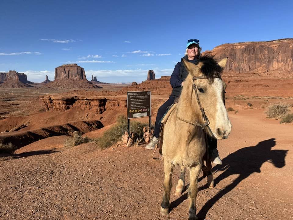 C. Robin Wyatt riding a horse in Monument Valley